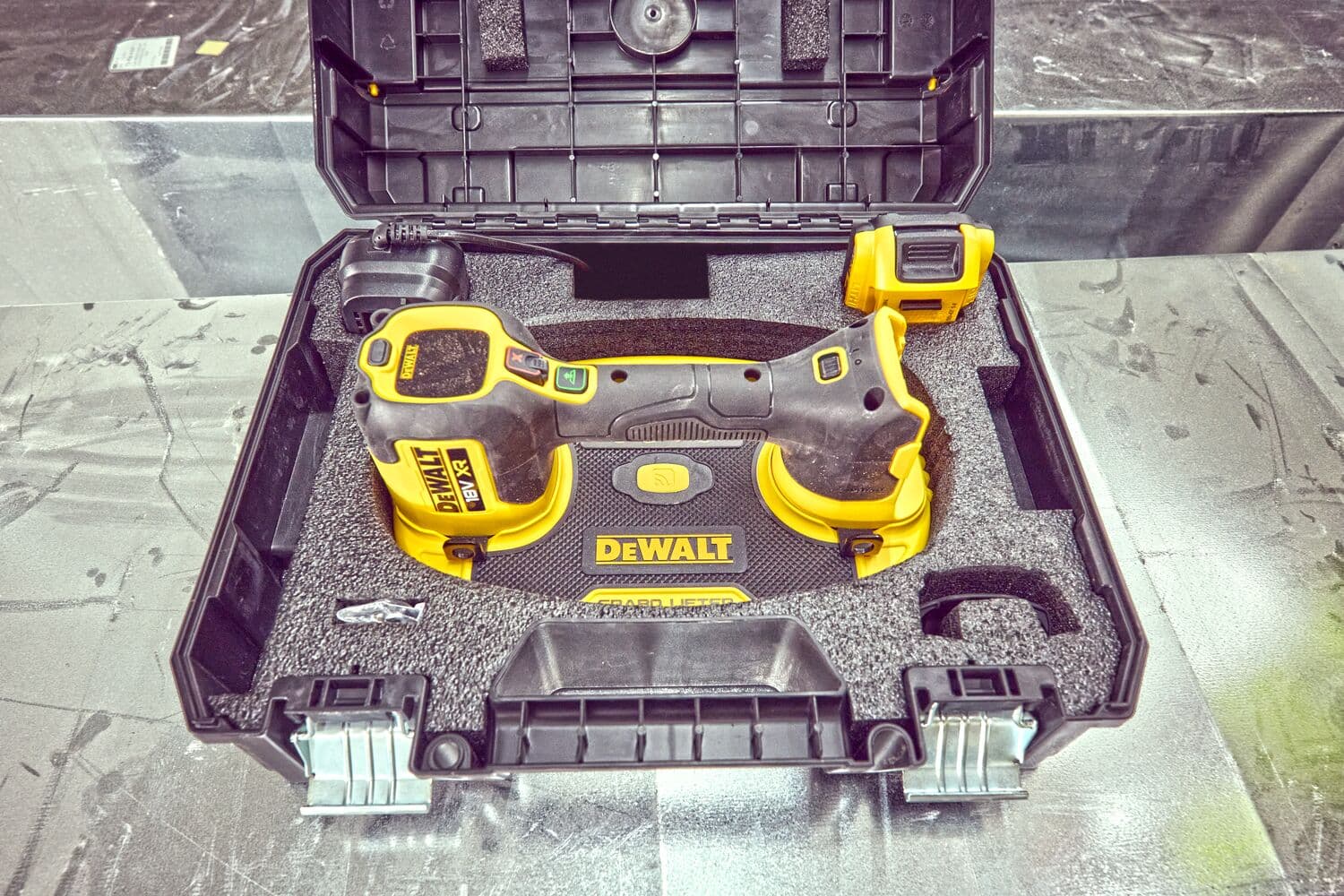 A DEWALT power tool in a black carrying case with foam padding, showing the tool and its accessories securely arranged inside the box.