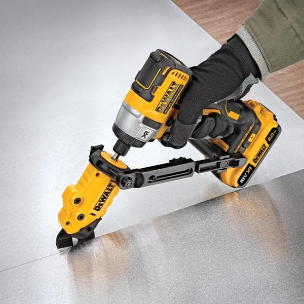 Una persona con guantes está utilizando una herramienta eléctrica amarilla y negra DEWALT DT70620 para cortar una lámina de metal. La herramienta funciona con batería y tiene un accesorio de corte para trabajos de precisión.