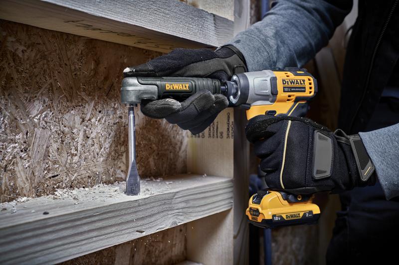 Una persona con guantes de trabajo usa un taladro inalámbrico DEWALT con un accesorio para perforar una viga de madera.