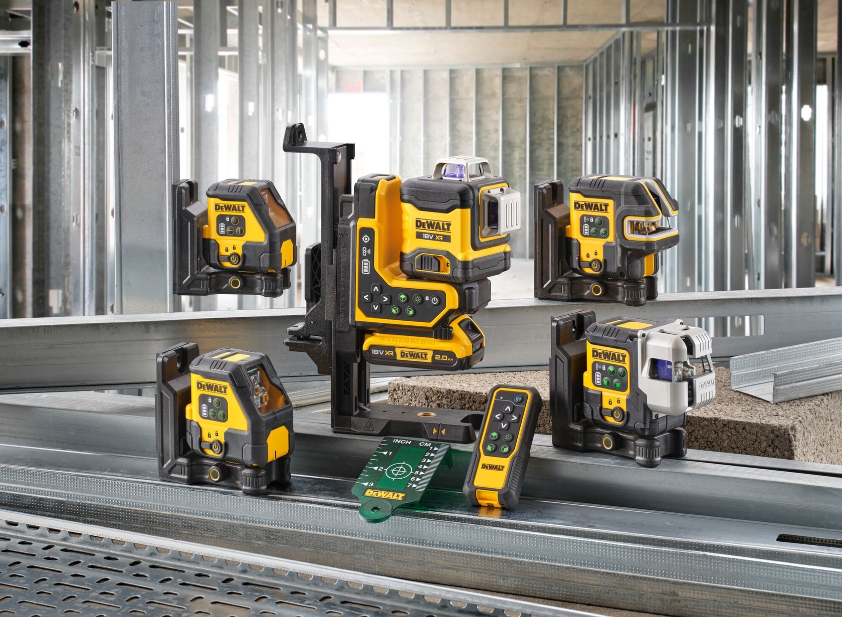 Una colección de niveles láser y herramientas de medición DEWALT mostrada en un sitio de construcción, con estructuras metálicas al fondo. Las herramientas son de color amarillo y negro y están colocadas sobre vigas de acero, junto a accesorios como un control remoto y una placa de destino para láser.