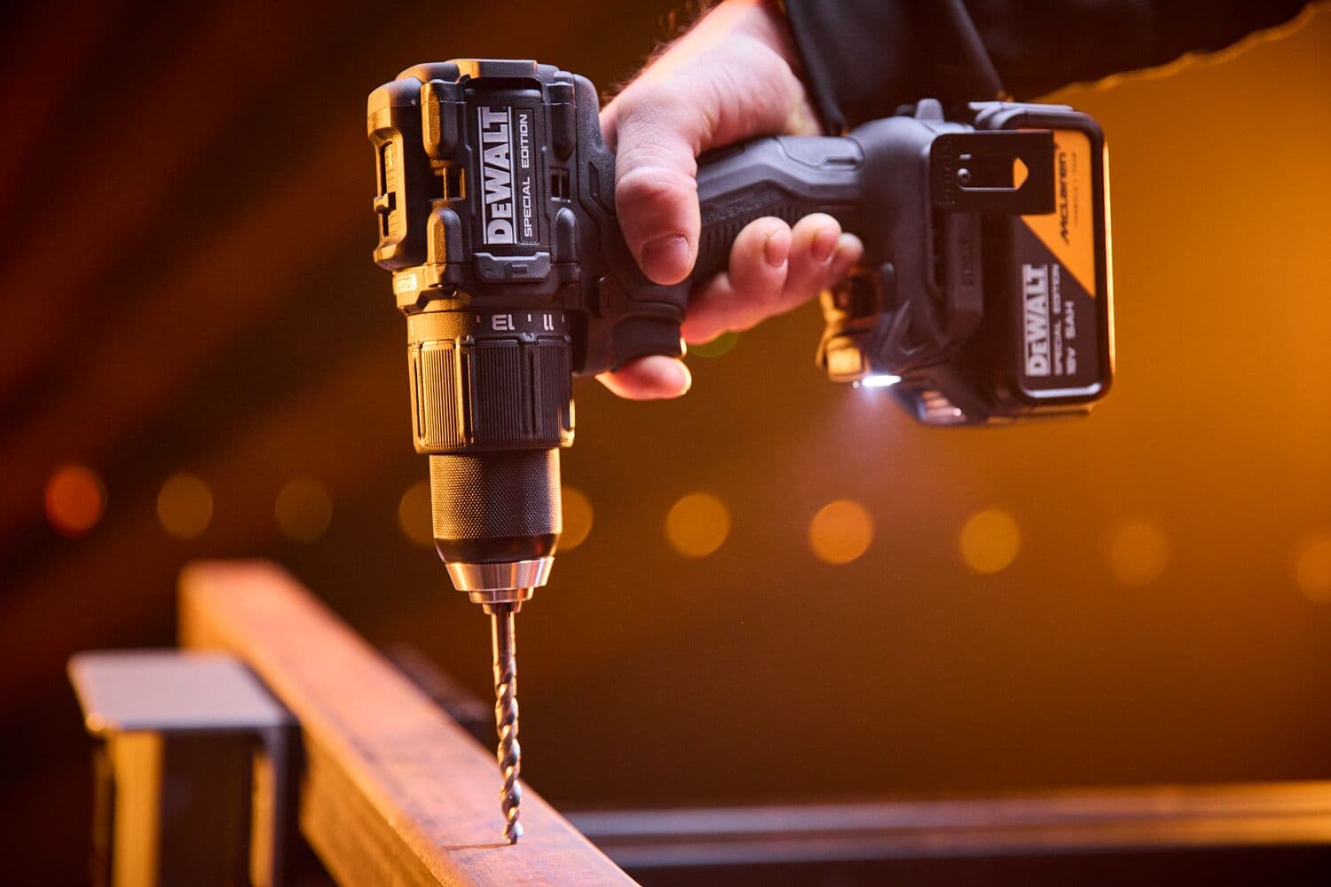 DEWALT x McLaren F1 Team 18V XR Special Edition Hammer Drill Driver with 5Ah battery drilling a metal bar