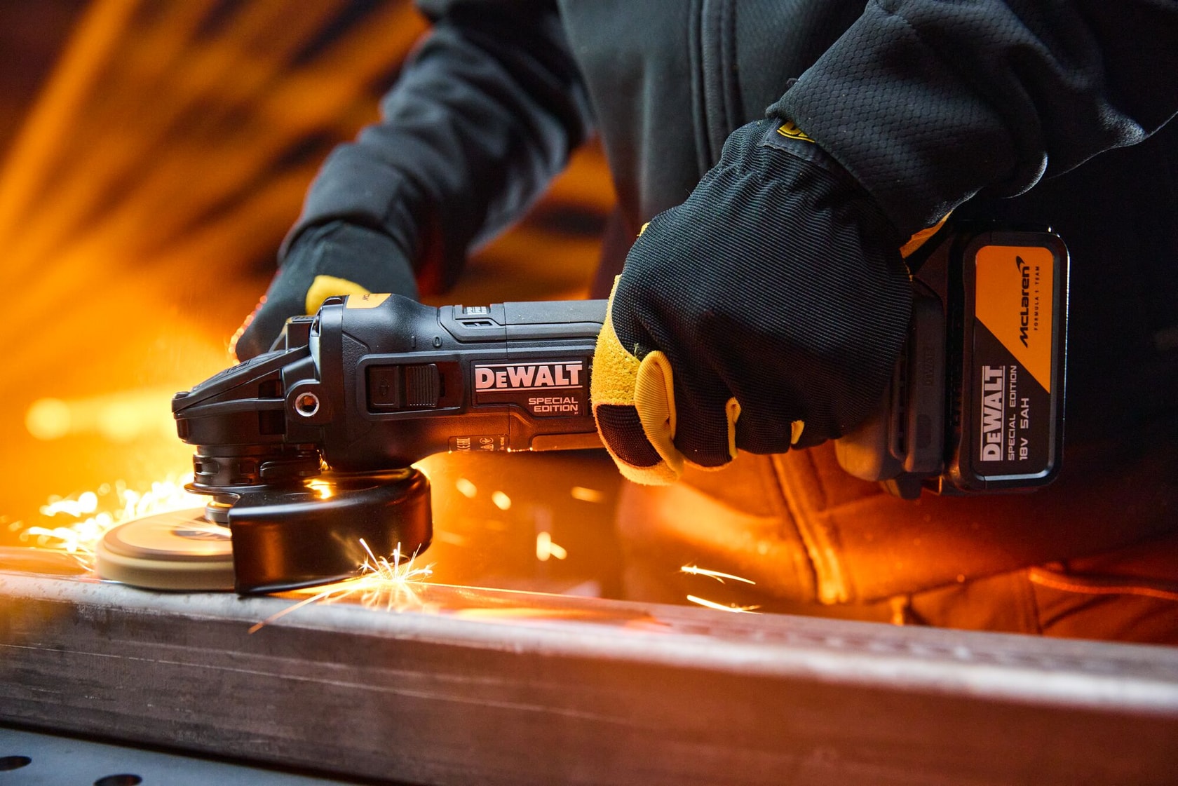 DEWALT x McLaren F1 Team 18V XR Special Edition Grinder with 5Ah battery grinding a metal bar